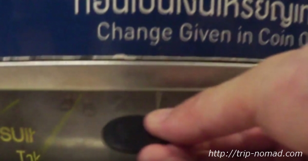 バンコク『MRT』券売機から黒いプラスティックのコイン型のチケット（トークン）を取り出す