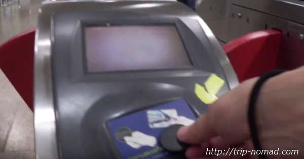 バンコク『MRT』自動改札機へコイン型チケットをタッチする